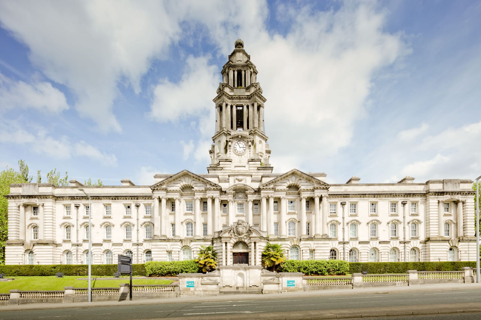 Stockport Town Hall, a stone Edwardian civic building with a clock tower, under a bright cloudy sky